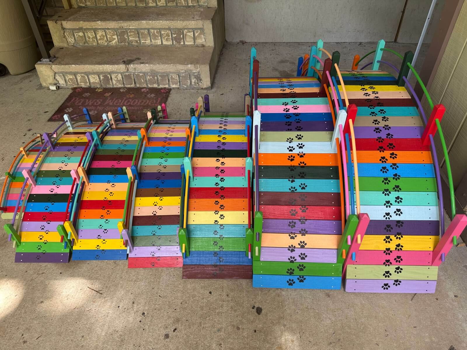 Dozens of Paul's handcrafted rainbow bridges from above, each unique with paw prints