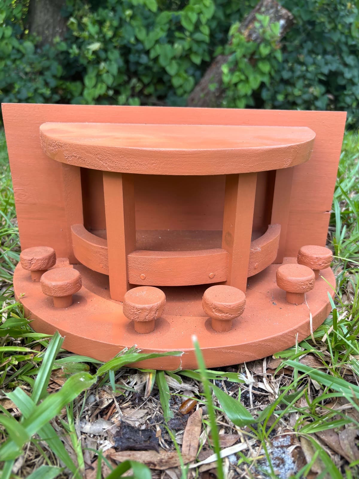 A burnt orange handcrafted squirrel feeder by Paul Allabaugh