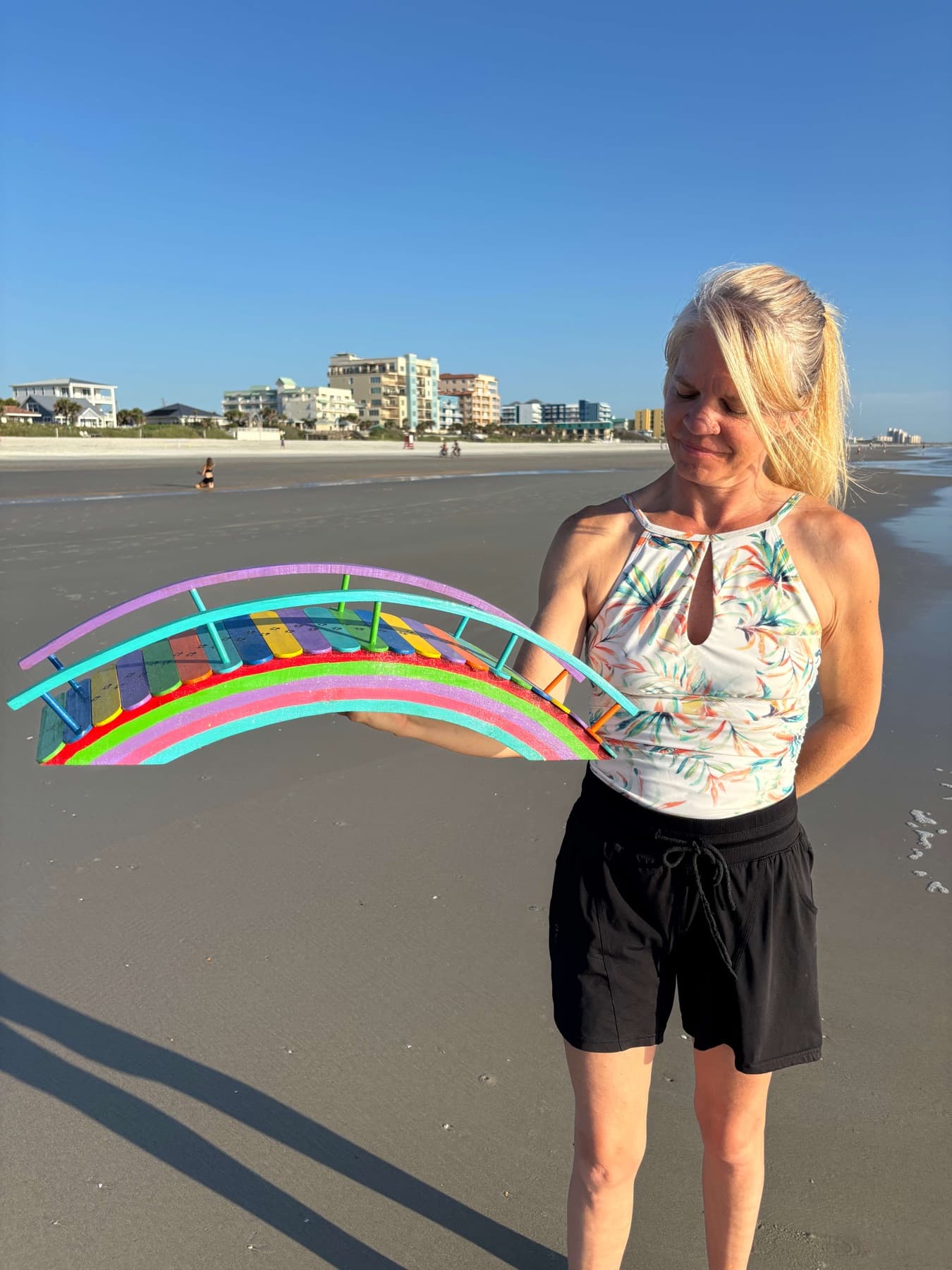 A Rainbow Bridge held up on the beach, the morning behind it