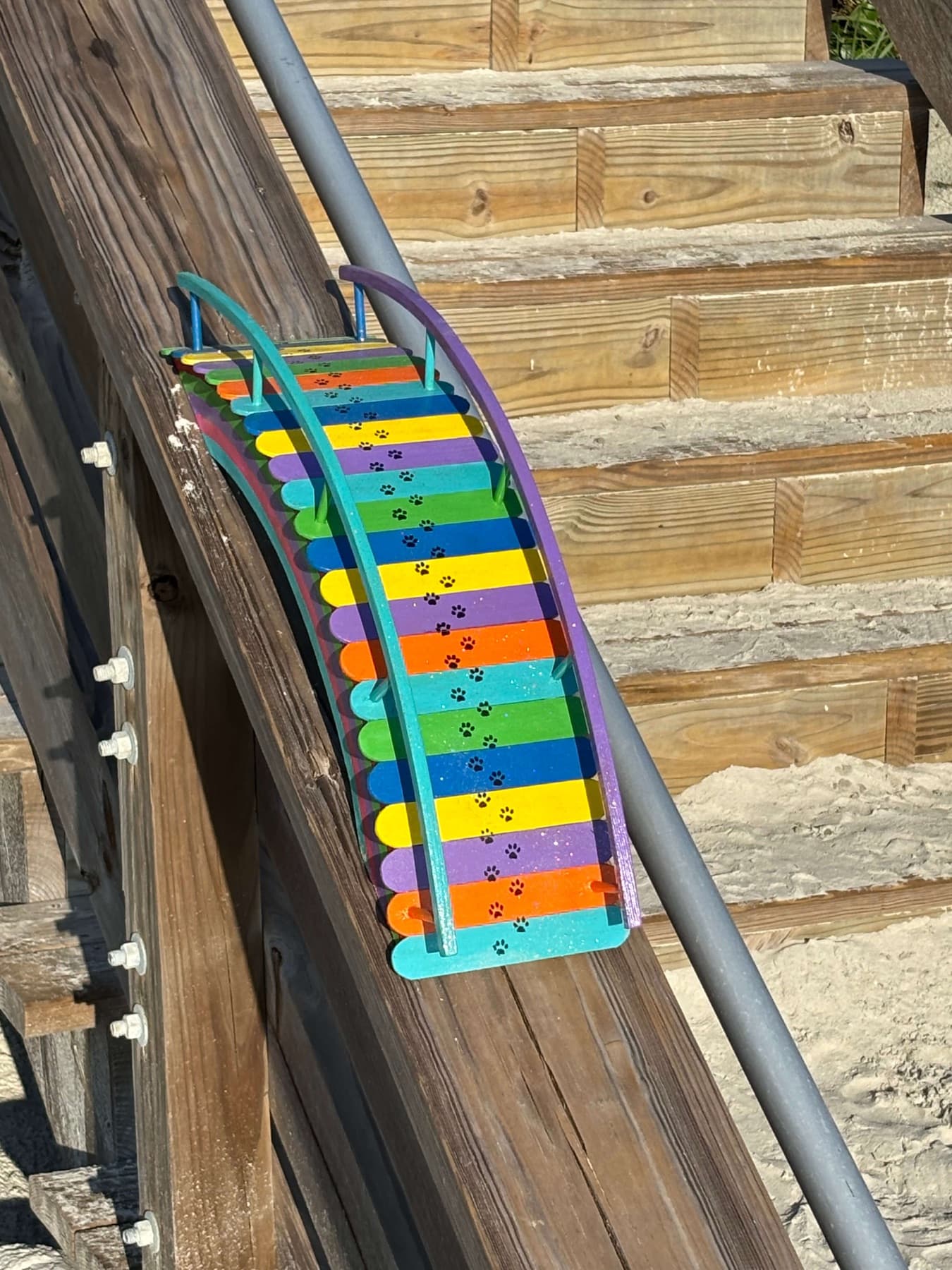 A Rainbow Bridge resting on a weathered beach boardwalk
