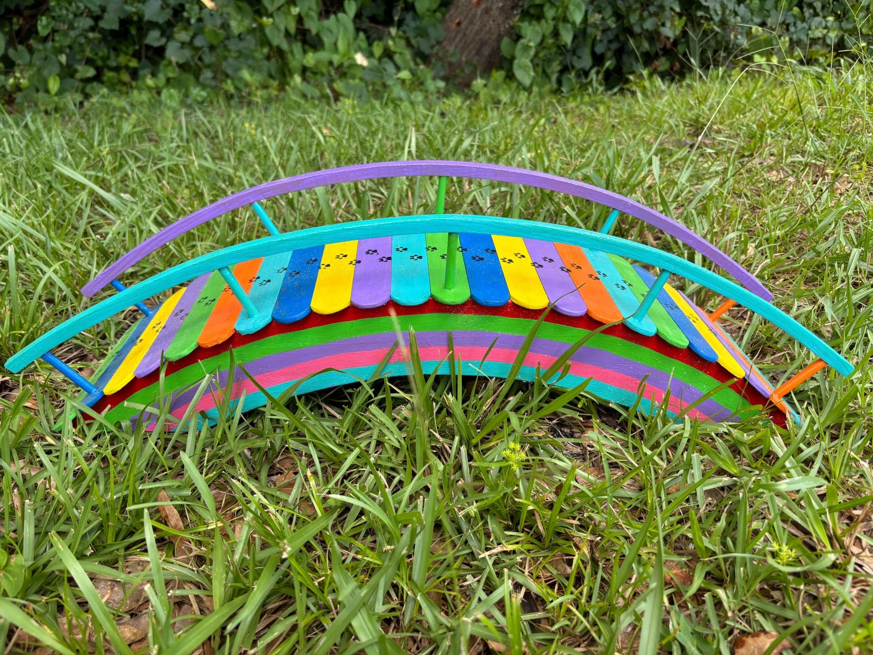 The first Rainbow Bridge giveaway bridge, handmade by Paul Allabaugh, seen from the side in the grass